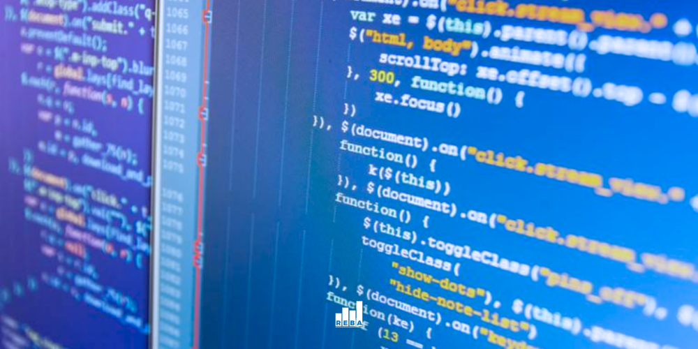 Close-up of a computer screen displaying colorful lines of JavaScript code, with syntax highlighted in blue, yellow, orange, and white on a dark background.