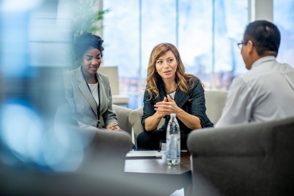 3 individuals meeting to discuss in a conference room